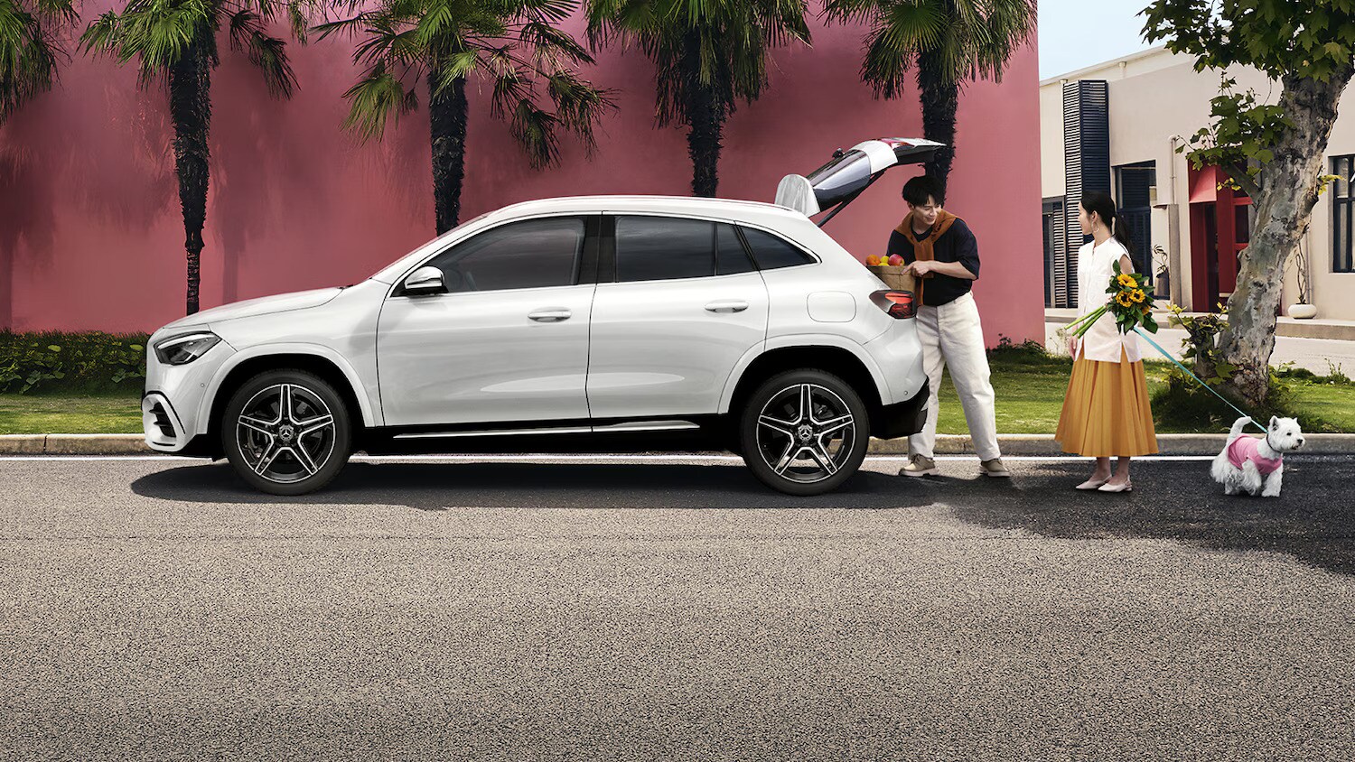 Couple loading groceries into a white GLA